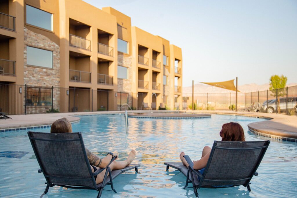 Two girls on beach chairs in the pool.