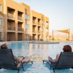 Two girls on beach chairs in the pool.
