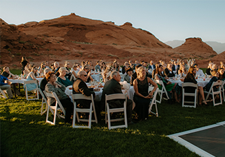 Guests seated at tables in the rock bowl at Sand Hollow Resort, enjoying a wedding reception.