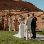 Wedding ceremony taking place in the rock bowl at Sand Hollow Resort, with guests and the beautiful desert landscape in the background.