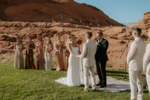 Wedding ceremony taking place in the rock bowl at Sand Hollow Resort, with guests and the beautiful desert landscape in the background.