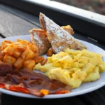 A delicious breakfast plate featuring eggs, crispy bacon, golden hashbrowns, and freshly baked scones at The Grille at Sand Hollow Resort.